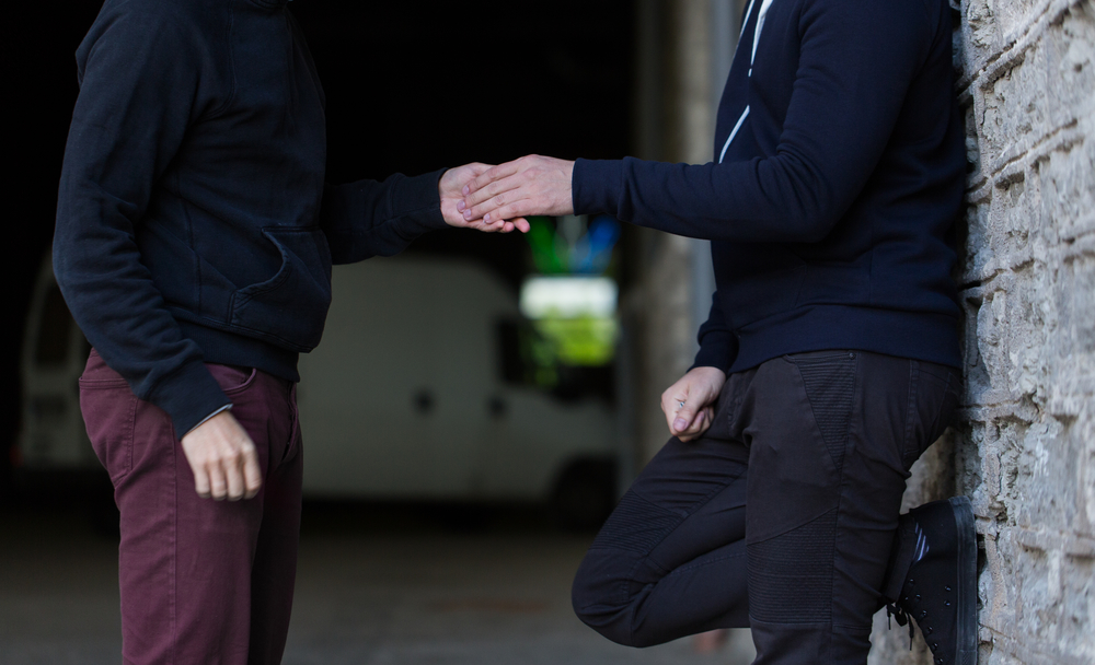 close up of addict buying dose from drug dealer