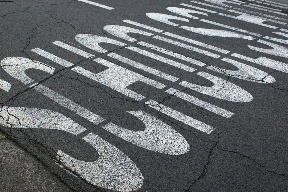 text on the pavement denots a school crossing.