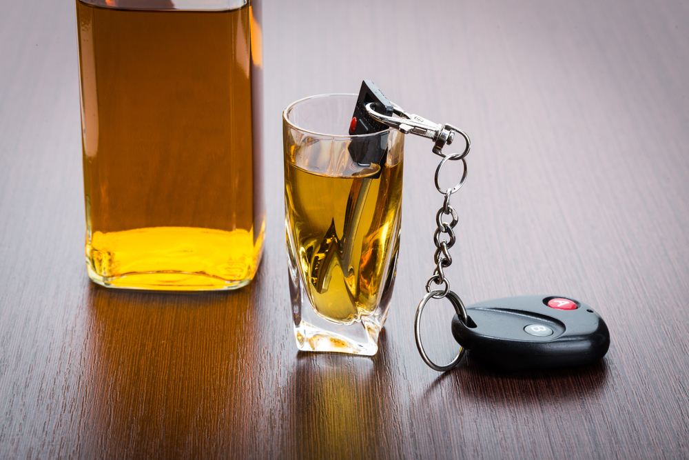 Car key on the bar with spilled alcohol