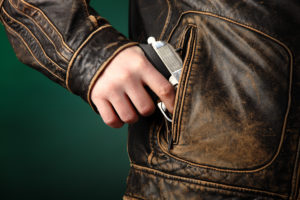 pulling gun out of jacket pocket