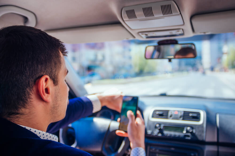 Reckless businessman driving in the city during the rush hour while talking on his phone.